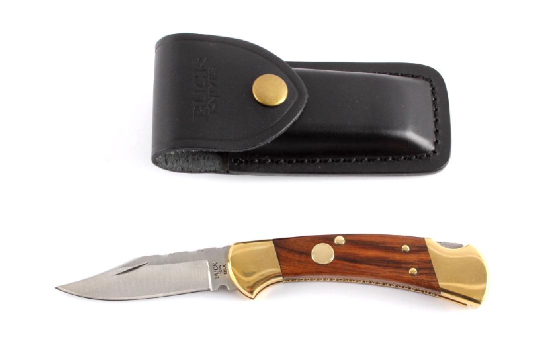 Buck 112 Custom Switchblade Knife w/ Scabbard: This is a Buck 112 Custom switchblade knife with leather scabbard. The knife features a hardened steel clip point blade marked "Buck 112 U.S.A.". The handle has brass bolsters with solid hardwood grip