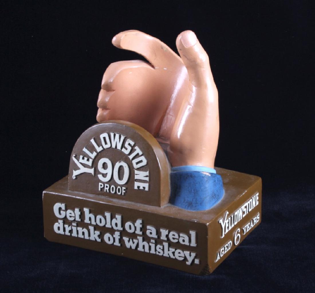 Yellowstone Whiskey Figural Barback Bottle Display: This is an original Yellowstone Whiskey figural barback bottle display. The piece shows a hand with a base that is marked "Yellowstone 90 Proof / Get Hold of a Real Drink of Whiskey / Yellowstone Aged