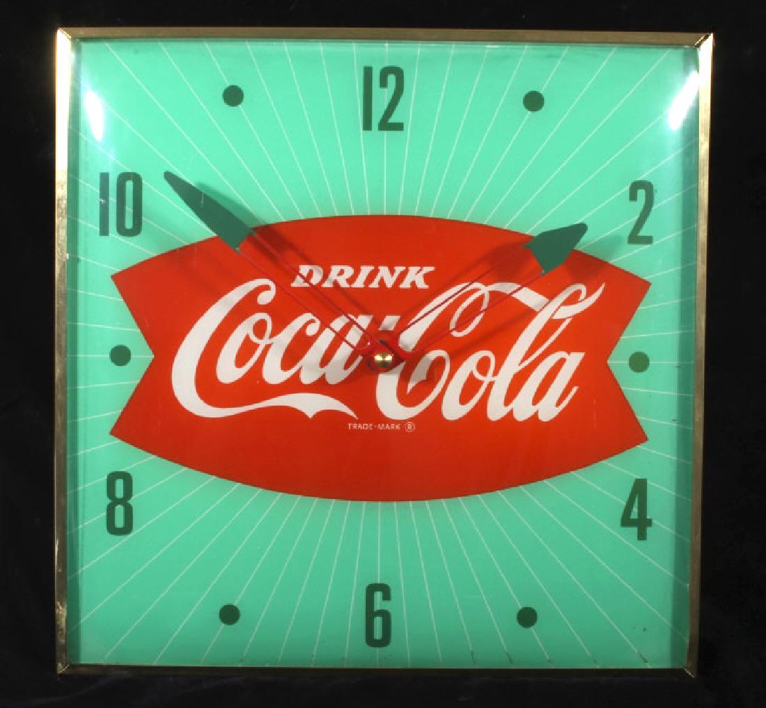 Vintage Coca Cola Advertising Clock: Vintage 1960's Coca-Cola Pam clock, red and green fishtail design. Clock has brass toned square case with curved glass cover. Classic Drink Coca-Cola trademark slogan centers the clock. Good color, no