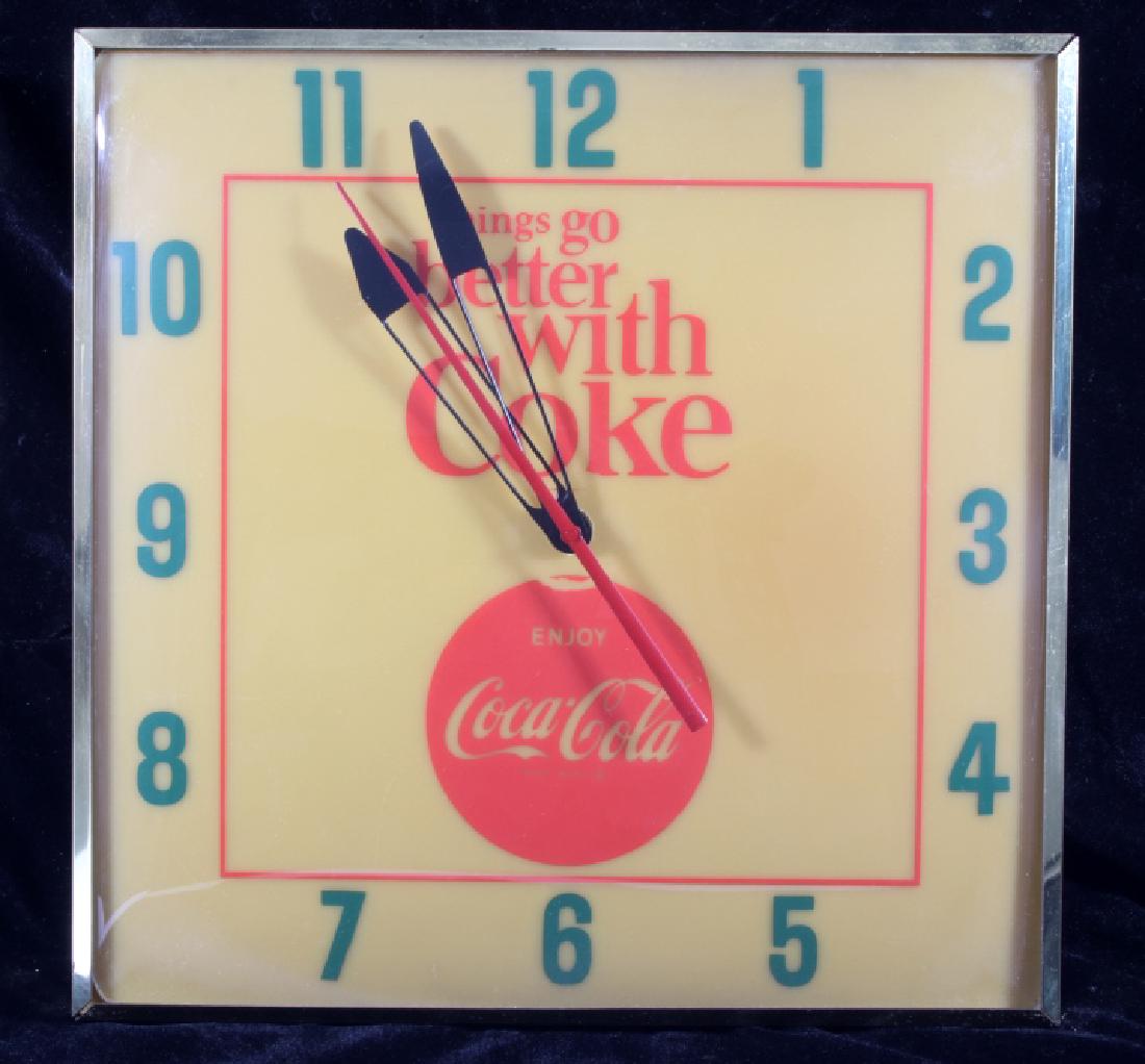 Vintage Coca-Cola Lighted Advertising Clock: This lot contains a vintage Coca-Cola illuminated clock. The face shows "things go better with coke" and the coca-cola trademark. The clock comes with a bronze tone encasing and curved glass cover, it