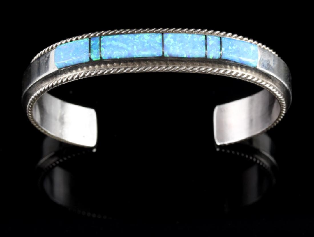 Fran Yazzie Navajo Inlaid Blue Opal Sterling Cuff: Provided for your consideration in this lot is a signed Fran Yazzie, Navajo Native American Indian cuff, or bracelet. The piece is crafted of heavy sterling silver, and shows a striking band of white 