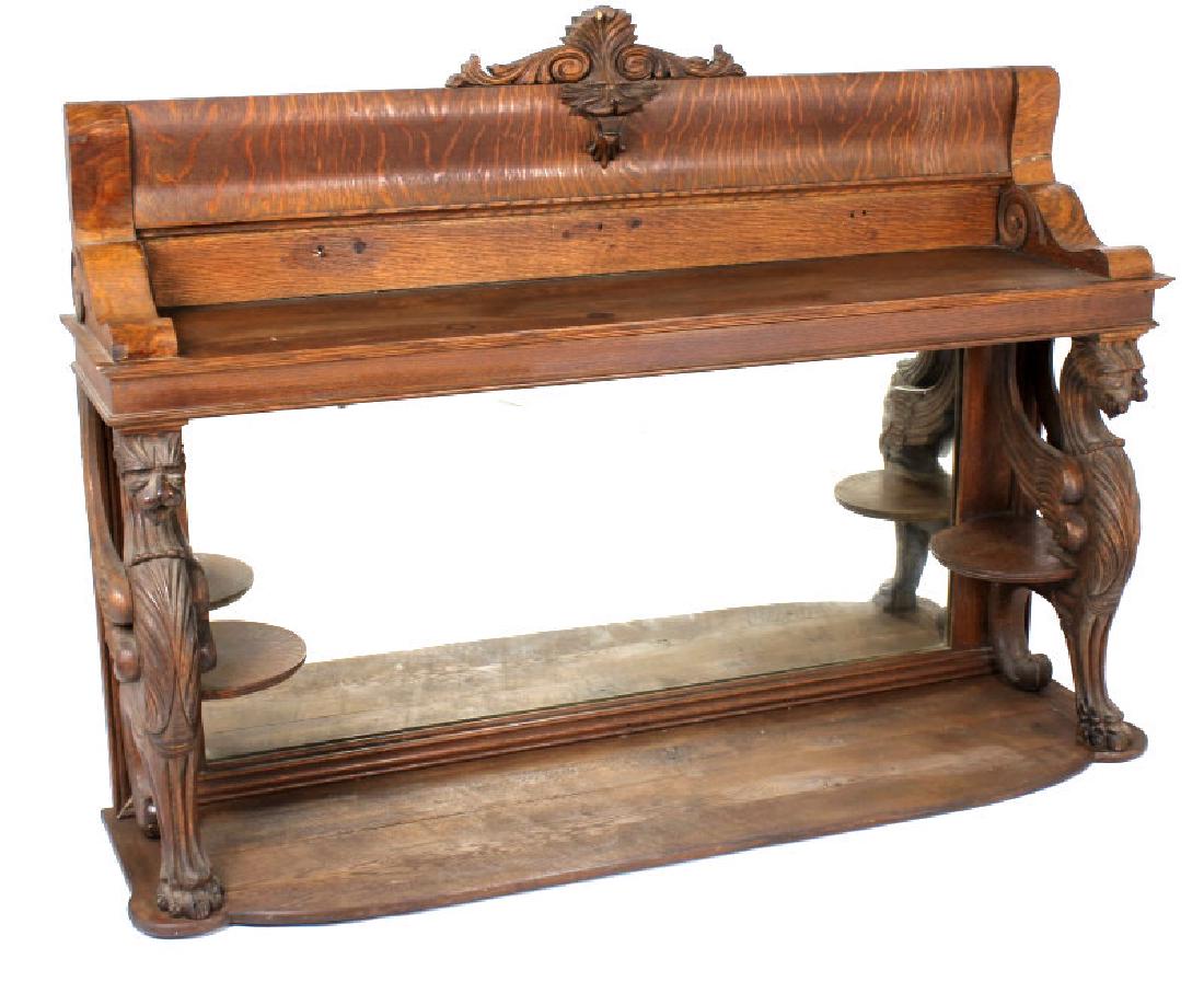 Early Man of the North & Griffon Bar Back Mirror: The lot features a fantastic Early American Sideboard mirrored bar back with a wonderful hand carved Griffon and Man of the North accents. The early 1900 piece shows a wonderful playful quarter sawn t