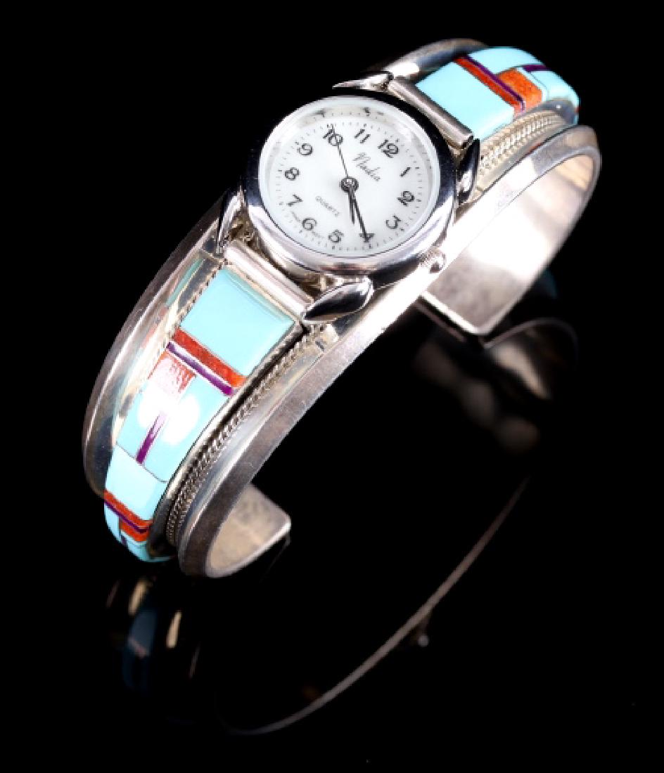 L Douglas Navajo Sterling Inlaid Mosaic Watch Cuff: This is a signed Navajo Native American Indian sterling silver and inlaid multi-stone mosaic watch cuff. The cuff boasts a blue gem turquoise, spiny red oyster, and sugilite geometric mosaic, and util