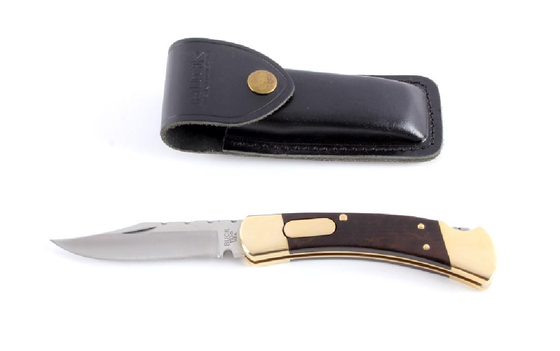 Buck 110 Custom Switchblade Knife w/ Scabbard: This is a Buck 110 Custom switchblade knife with leather scabbard. The knife features a hardened steel clip point blade marked "Buck 110 U.S.A.". The handle has brass bolsters with solid hardwood grip