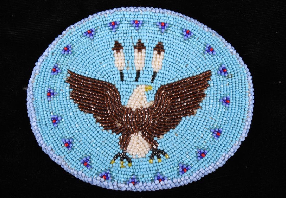 Crow Indian Eagle Beaded Round Belt Buckle: For sale in this lot we have a Crow Native American eagle beaded belt buckle. The buckle features a bald eagle with three feathers above it head. The buckle is made of tanned leather with glass trade 