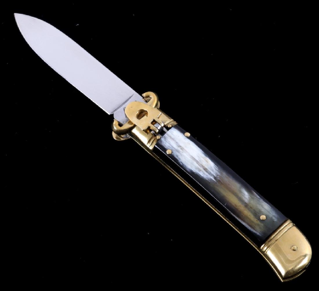 Italian Buffalo Horn Shot Puller Switchblade Knife: This is an Italian made buffalo horn lever lock switchblade shot shell puller knife. The knife features a genuine buffalo horn handle set with a hardened steel blade that is marked "AKC Italy" and bra