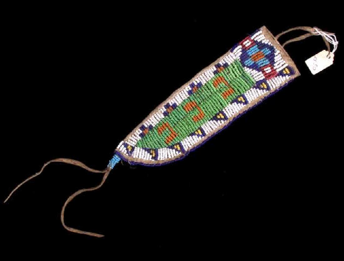 Early Lakota Sioux Beaded Trade Knife Scabbard: The lot features a small trade knife beaded sheath from the Lakota Sioux Native American Indians. The sheath shows an Indian tanned hide construction with glass trade seed bead work in a traditional g
