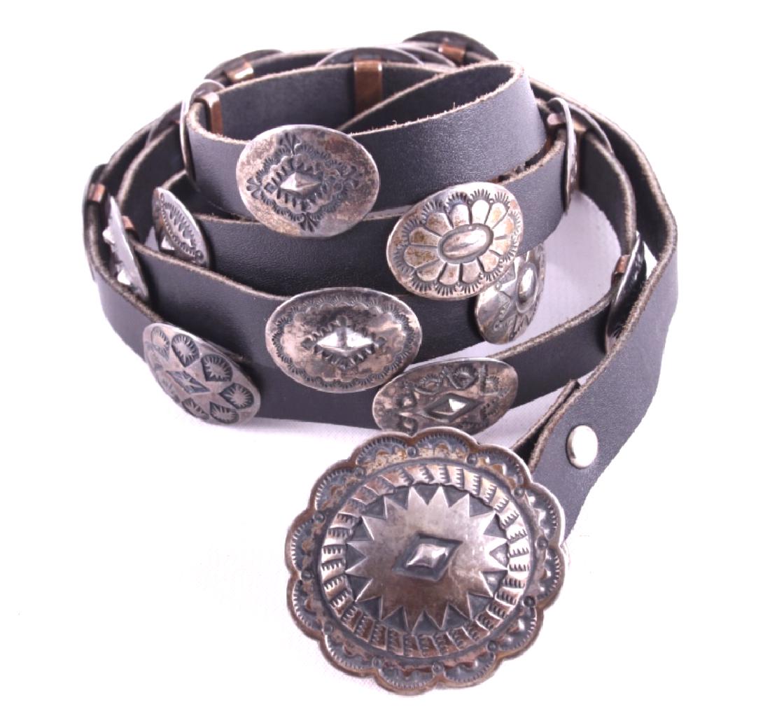 Navajo Native American Sterling Concho Belt: For sale in this lot is a Navajo Native American sterling silver concho belt. The belt showcases twenty sterling conchos. Each concho is unique and securely fastened to the black top grain leather bel