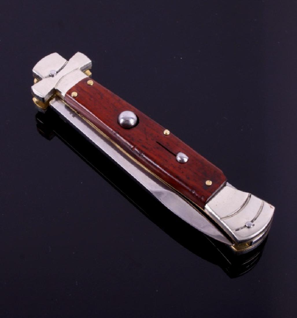 Campolin Maltese Cross Italian Switchblade Knife: This is a genuine Campolin imported Italian made Maltese Cross stiletto switchblade knife. The knife features the Maltese Cross hilt and solid cocobolo hardwood grips with a push button to release the