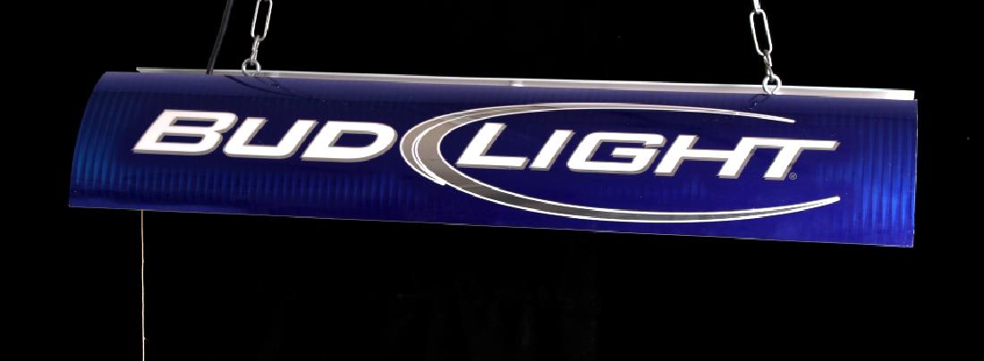 Bud Light Pool Table Light: Offered in this lot we have a Bud Light pool table light. The light is made of metal and fiberglass. The piece is colored in a deep blue, silver, and white. The light is designed to hang above a pool