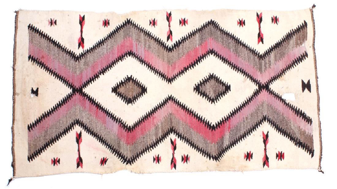 Navajo Native American Ganado Hand Woven Rug: Featured in this lot we have a Navajo Native American Ganado hand woven wool rug originating from the early to mid 20th century. The rug shows a borderless tan field with a diamond patterns at the cen