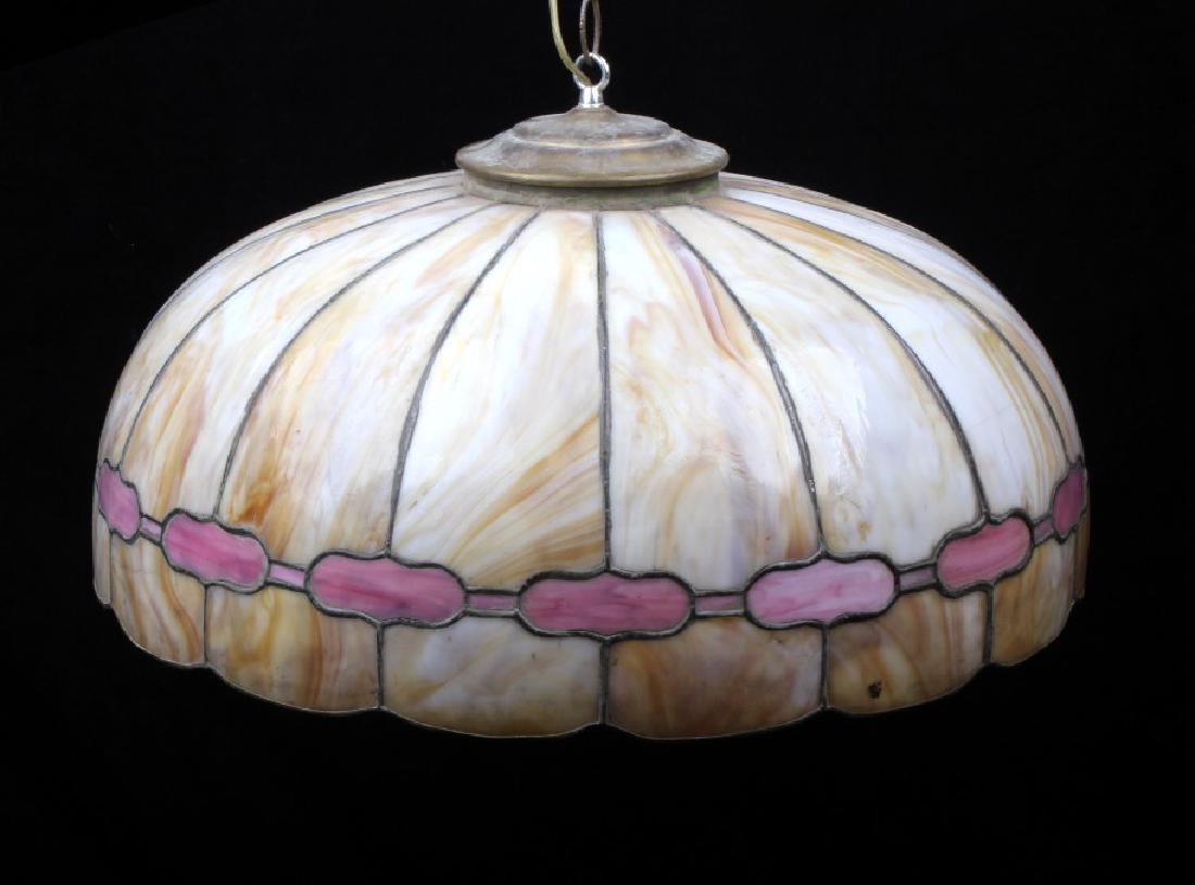 Vintage Stained Glass Chandelier: Provided for your consideration in this lot is a vintage stained glass chandelier. The lamp shows a caramel color accented with pink glass. The glass panels are leaded at the creases and features a ch