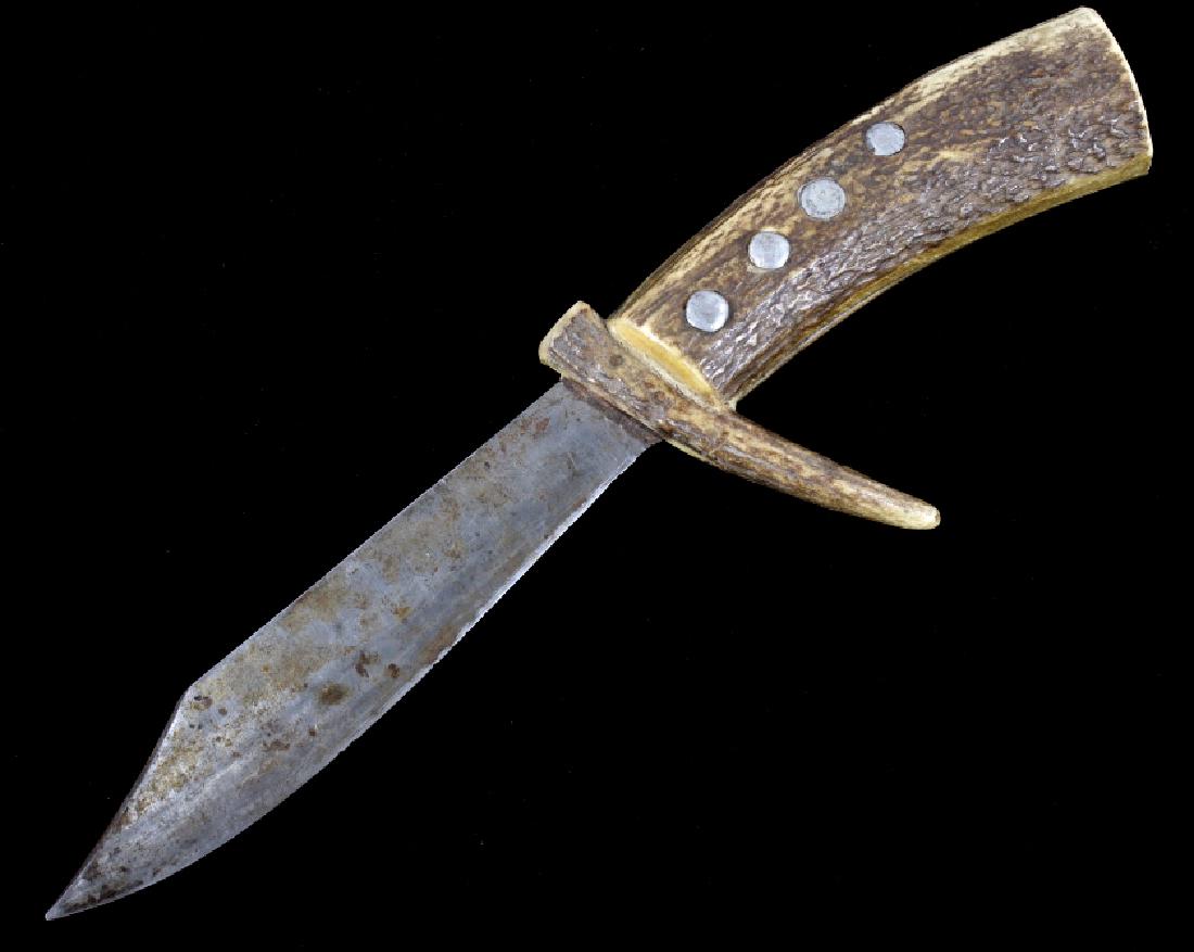 Montana Crow Elk Antler Knife c. 1900-1920: The lot features an excellent original circa 1900-1920's bowie knife with elk antler handle from the Crow Native American Indians of Montana. The piece shows a heavy iron forged bowie knife clip point