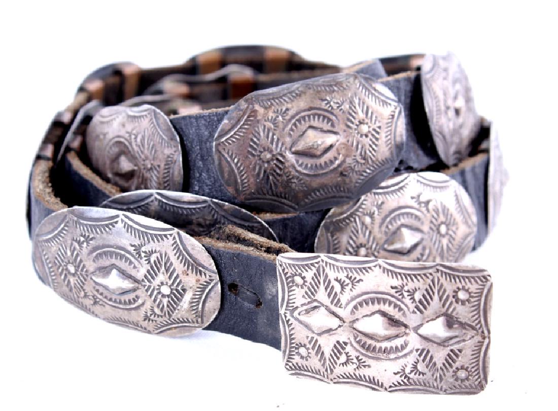 Navajo Old Pawn Silver Concho Belt: Included in this lot is a Navajo Native American Old Pawn silver concho belt. The piece is crafted of 15 sterling silver conchos and a buckle. Each concho is attached by copper straps. The belt shows 