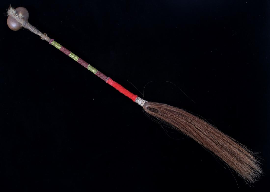 Sioux Beaded Stone Head War Club w/ Horsehair Drop: The lot features a Sioux Native American Indian beaded stone head war club. The club shows a wood haft which is covered in wolf rawhide and has a liniear section of corn yellow and dark red glass bead