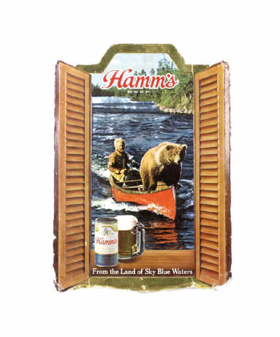 Vintage Hamm's Beer Advertising Sign: Available for your bidding pleasure we have a vintage Hamm's Beer advertising sign. This sign reads "Hamm's Beer / From the Land of Sky Blue Waters". The image this sign shows a "framed" image of a ge
