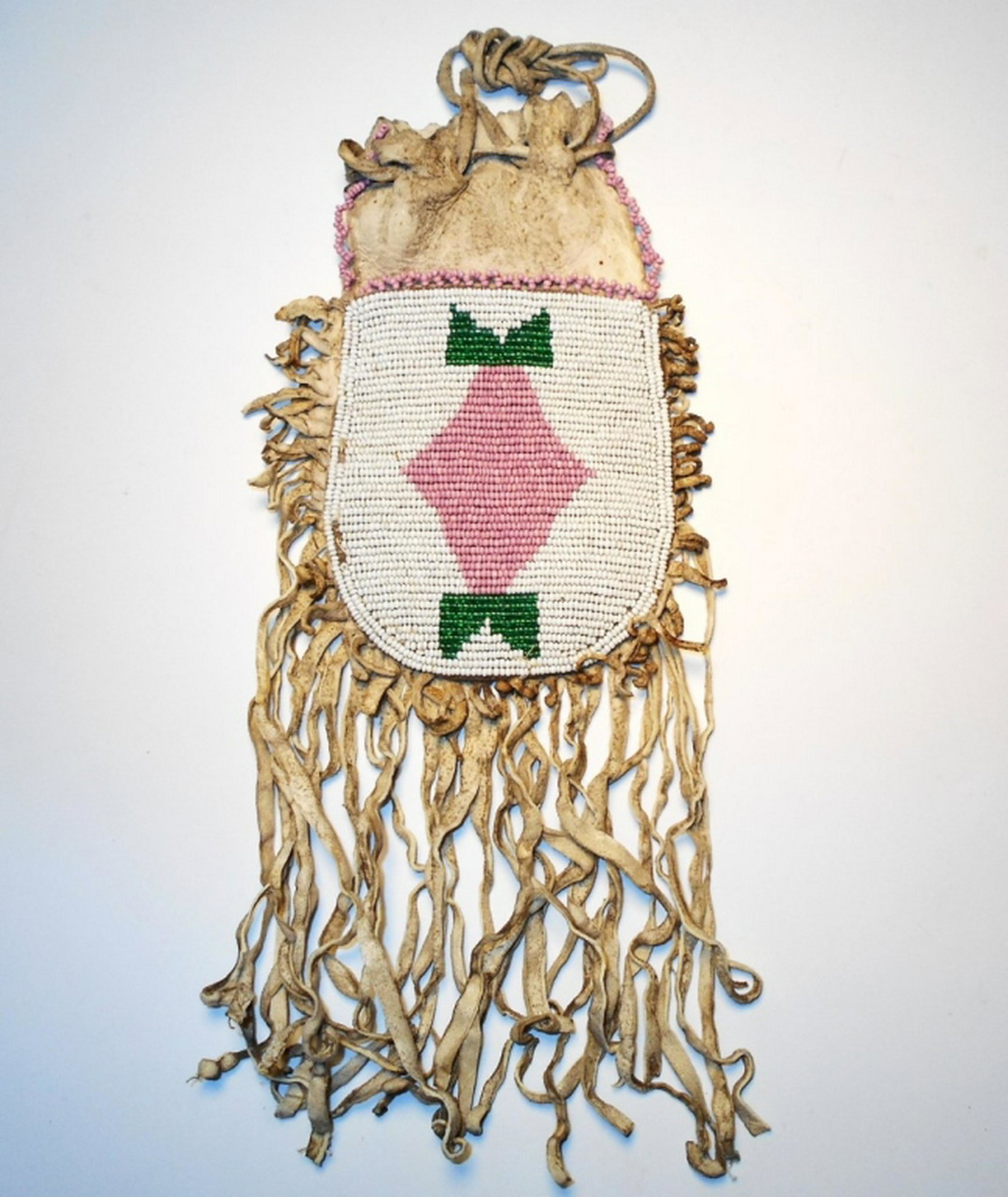 Comanche Beaded Medicine Pouch 19th Century: The lot features a beaded Southern Plains medicine pouch from the Comanche American Indians of Northern Texas and dating to the 19th Century. The bag shows an Indian tanned hide which is sinew sewn an