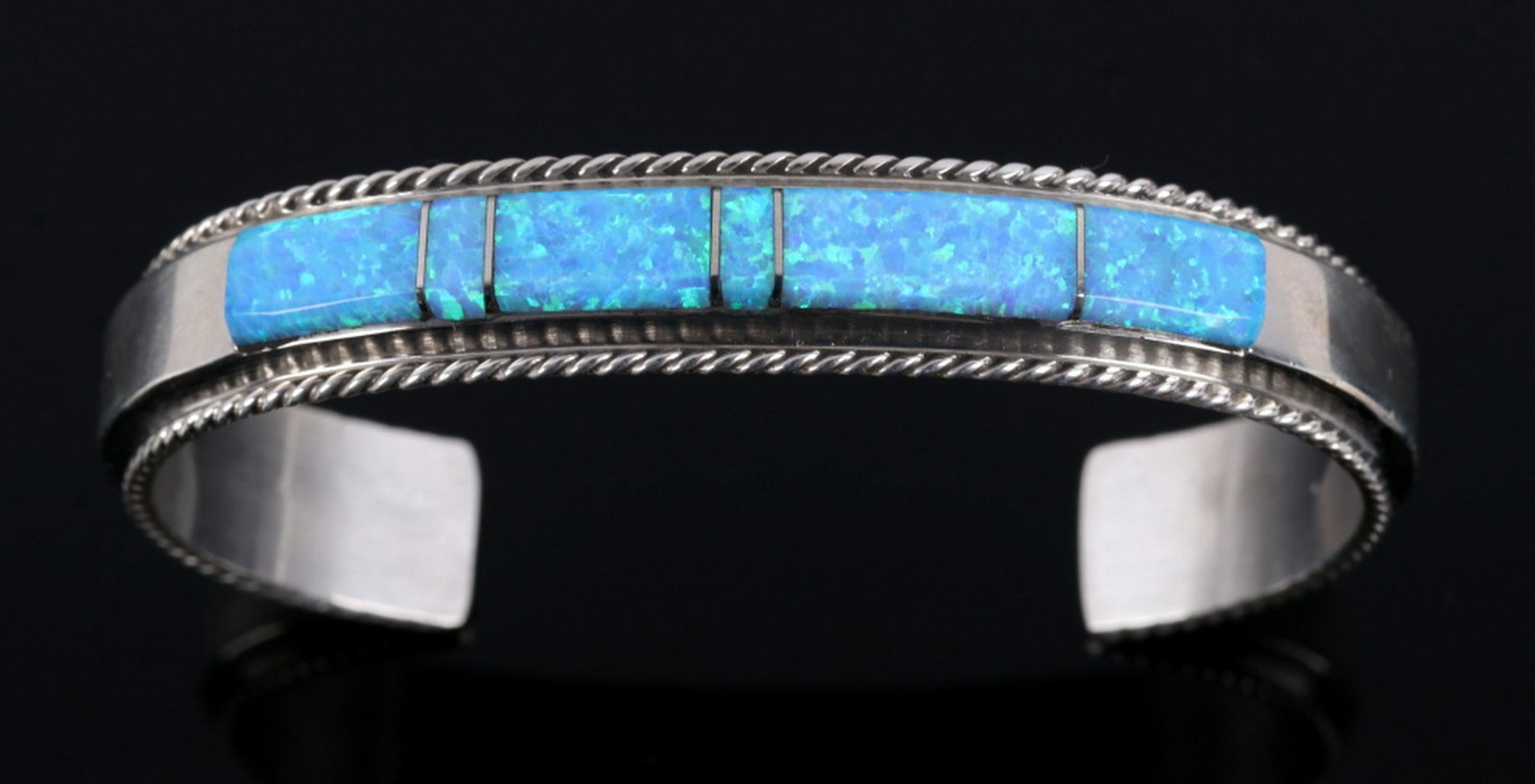 Fran Yazzie Navajo Inlaid Blue Opal Sterling Cuff: For bidding in this lot is a signed Fran Yazzie, Navajo Native American Indian cuff, or bracelet. The piece is crafted of heavy sterling silver, and shows a striking band of blue opal laid across the 