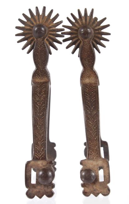Original Buermann Western Cowboy Spurs: Offered in this lot we have a pair of original Buermann western iron cowboy spurs. The spurs show iron construction with engraved chasing along the outside edge. Each spur features a straight shank wi
