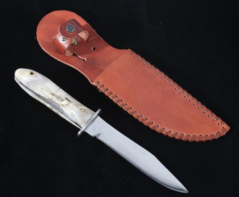 Deer Antler Knife with Leather Sheath: Offered in this lot we have a antler handled buck knife with a leather sheath. The knife features a steel blade with the traditional clipped style buck knife blade. The piece shows a steel guard and a