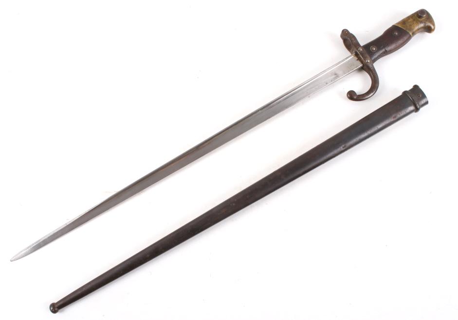 French M1874 WWI Sword Bayonet w/ Scabbard: Available in this lot we have a French M1874 sword bayonet with metal scabbard originating from 1879. The piece shows a steel blade with a metal guard, wooden grip, and brass attachment point. The bay