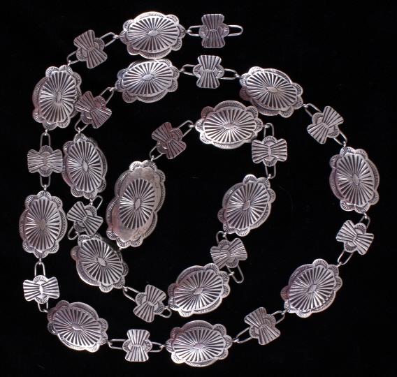 Navajo Sterling Silver Concho Belt: Included in this lot is a Navajo Native American sterling silver concho belt. The belt features fifteen solid sterling silver conchos and fifteen silver bowtie links. The conchos display a traditional
