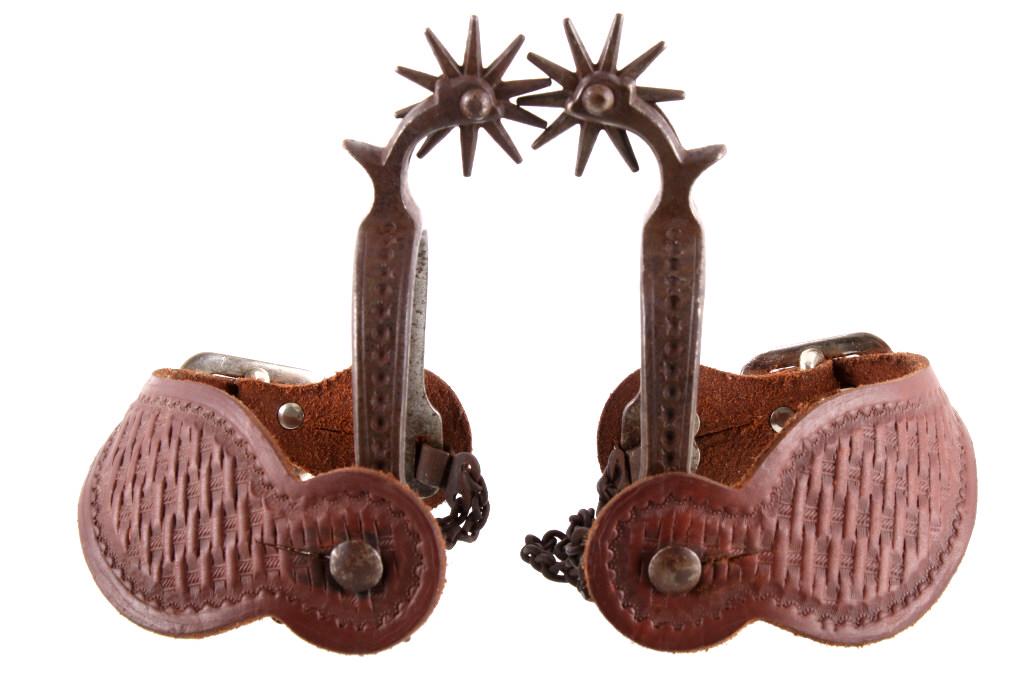 August Buermann Sun Spot Engraved Spurs c. 1890: The lot features a set of early August Buermann unmarked spurs with tooled spur straps. The set dates to circa 1890’s and shows a Texas one-piece pattern with single side engraving having a two-line