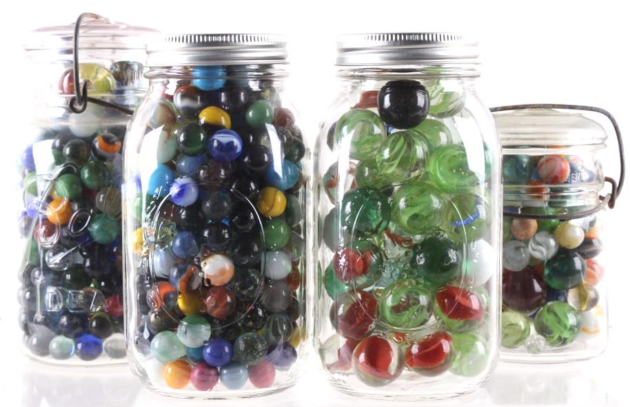 Collection of Various Sized Marbles In Mason Jars: In this lot we have a collection of various sized marbles. These marbles range from a diameter of 1" to 1/2". The also have a variety of colors with some of them being transparent. there is over 100 m
