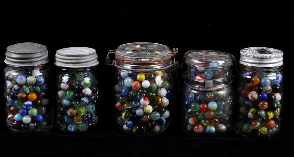 Collection of Assorted Marbles in Jars: Available in this lot we have a collection of five jars with assorted marbles. The collection includes hand made, stone, clay, latticino-core, ribbon-core, coreless swirl, superman, cateye, and many, 