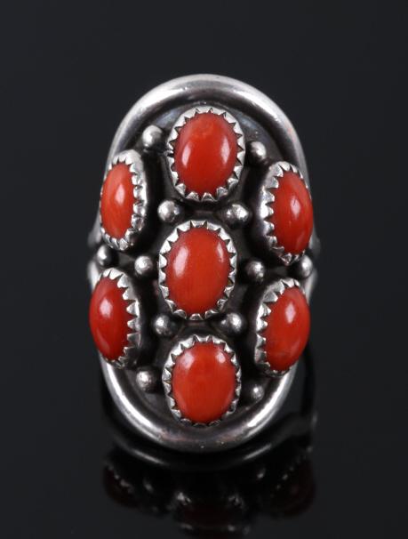 Navajo Sterling Silver & Ox Blood Coral Ring: Available in this lot we have a Navajo Native American sterling silver and coral ring. The ring displays sterling silver construction with twelve silver droplets across the face. The top of the ring f