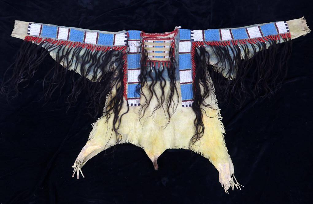 Sioux Beaded Hide War Shirt w/ Horsehair Fringe: This is an exceptional beaded men’s war shirt from the Sioux Native American Indians. The piece shows an Indian tanned Rocky Mountain Elk hide which has amazing traditional war shirt beaded panels d