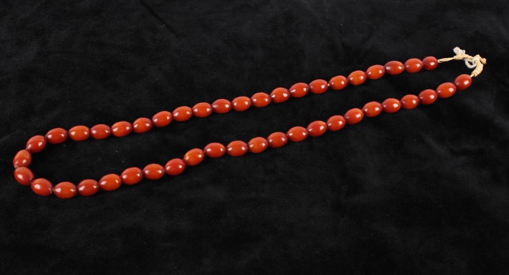 Antique African Hand Carved Copal Trade Beads: Offered in this lot is a string of forty five antique African hand carved Copal trade beads These beads are strung on raffia. The beads are polished to a medium shine. The beads have a warm mahogany c