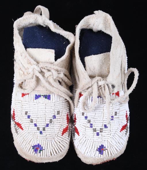 Northern Cheyenne Fully Beaded Child's Moccasins: The set features a finely crafted hide constructed moccasins with gorgeous fully top beaded adornement and is from the Northern Cheyenne Native American Indians. The set shows an Indian tanned hide co