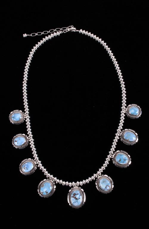 Navajo Golden Hills Turquoise Sterling Necklace: Included in this lot is a Navajo Native American Larry M. Yazzie Golden Hills turquoise sterling silver necklace. This necklace features nine stunning pendants of Golden Hills turquoise. These cabocho