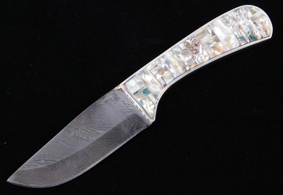 Navajo Wilson Dawes Abalone Shell Damascus Knife: This lot features an outstanding work of art, authentic Abalone shell inlaid, handmade Damascus knife by Navajo Native American master silversmith, Wilson Dawes. The piece shows a drop point style bla