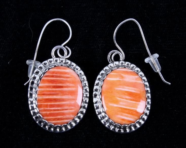 Navajo Herbert Tsosie Spiny Oyster Silver Earrings: Included in this lot is a pair of Navajo Native American, Herbert Tsosie orange spiny oyster and sterling silver earrings. The earrings feature a shadow box design with cabochons of spiny oyster on a 