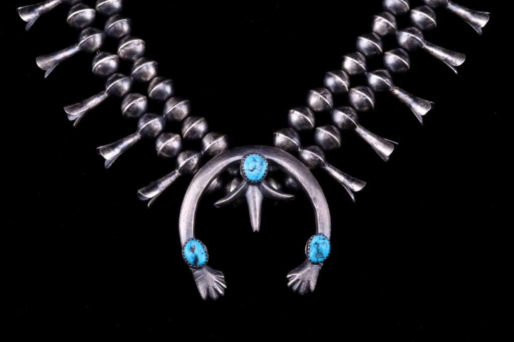 Navajo Old Pawn Style Turquoise Squash Blossom: The lot features an exceptional hand crafted sterling silver squash blossom necklace by Gerald Mitchell, master Navajo Native American Indian silversmith. The piece shows a tufa sand cast squash Naja 