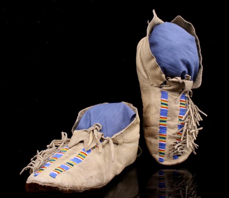 Kiowa Comanche Beaded Moccasins w/ Cowhide Soles: The lot features an unusual set of Kiowa Comanche Native American Indian attributed moccasins with beaded adornment and cowhide/steer hide soles. The set has a tanned hide construction with typical Ki