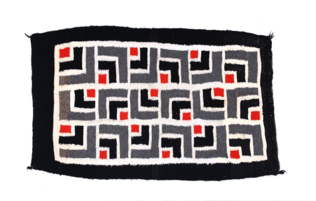 Navajo Ganado Stepped Pattern Wool Rug c. 1950s: Featured in this lot is this Navajo Ganado stepped pattern wool rug, circa 1950's. The rug shows a solid black border with a unique 'L' shaped stepped pattern set into individual square decorations. T