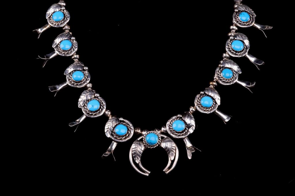 Navajo Sleeping Beauty Turquoise Squash Blossom: Featured in this lot is a Navajo Native American sterling silver, sleeping beauty turquoise squash blossom necklace. This fine piece shows a large central Naja pendant, flanked on both sides by five b