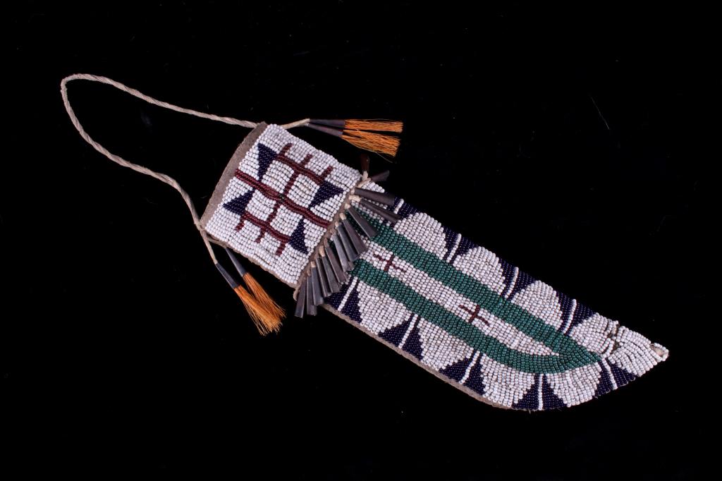 Lakota Sioux Beaded Hide & Parfleche Knife Sheath: The lot features a parfleche rawhide sheath with Indian tanned hide wrapping that is covered in glass trade seed beadwork in a fine geometric pattern attributed to the Lakota Sioux Native American Ind
