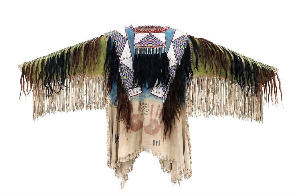 Sioux Style Beaded Hide War Shirt w/ Fringe: Featured in this lot is this exceptional beaded men’s war shirt from the Cherokee artist, Jue Hardin, and made in the Sioux Indian style war shirt. The piece shows an Indian tanned Rocky Mountain El