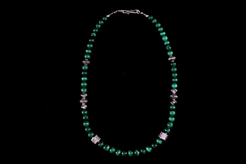 Navajo Sterling Silver & Malachite Necklace: Featured in this lot is this Navajo sterling silver and malachite necklace. The necklace shows 49 total spherical malachite stones and 10 sterling silver floral decorated Navajo charms. The necklace i