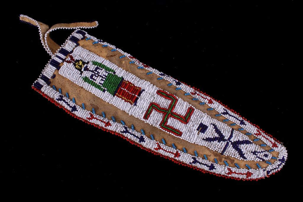 Sioux Beaded Whirling Logs & Warrior Hide Sheath: The lot features an Indian tanned hide, large knife sheath with elaborate beadwork attributed to the Sioux Native American Indians. The front shows a geometric and symbolic pattern with human warrior