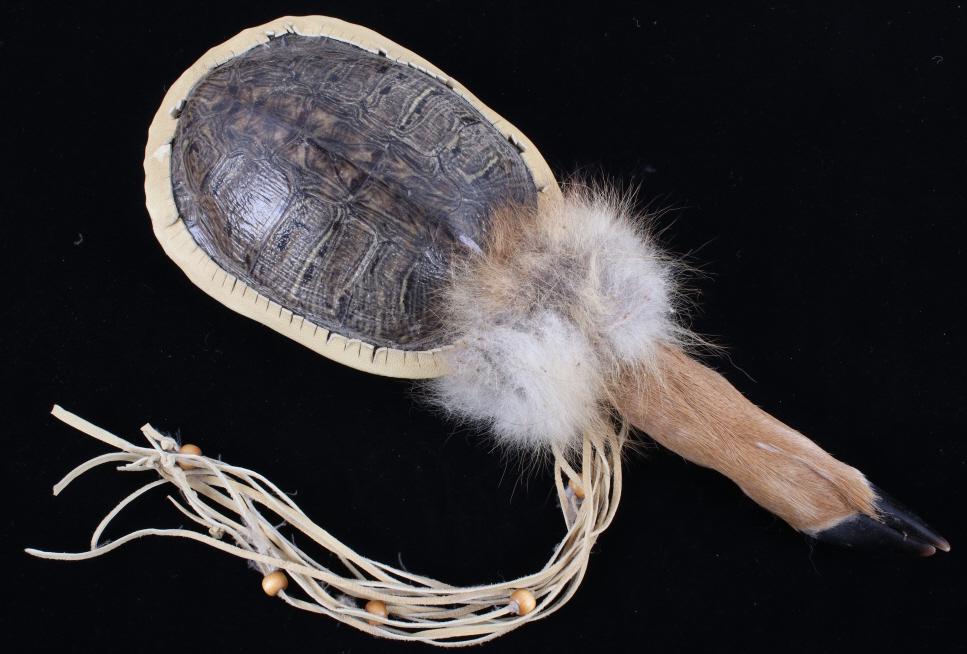 Blackfoot Indian Turtle Shell Deer Dance Rattle: Featured in this lot is a Blackfoot Native American Indian turtle shell and deer dance rattle. The dance rattle displays a complete turtle shell top and bottom with a deer hoof handle. The top shows l