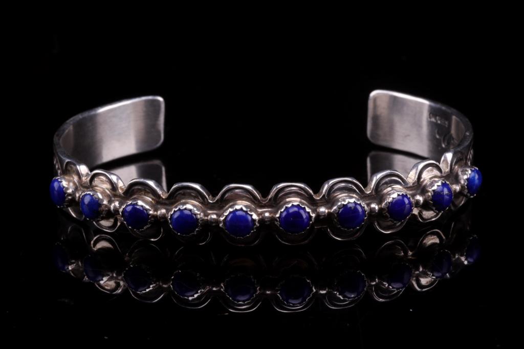 Navajo M. Willie Do Silver & Lapis Lazuli Bracelet: Featured in this lot is this sterling silver and lapis lazuli bracelet from Navajo artist M. Willie Do. The bracelet shows lovely sterling silver design with iconic Navajo stamped decoration to the sh