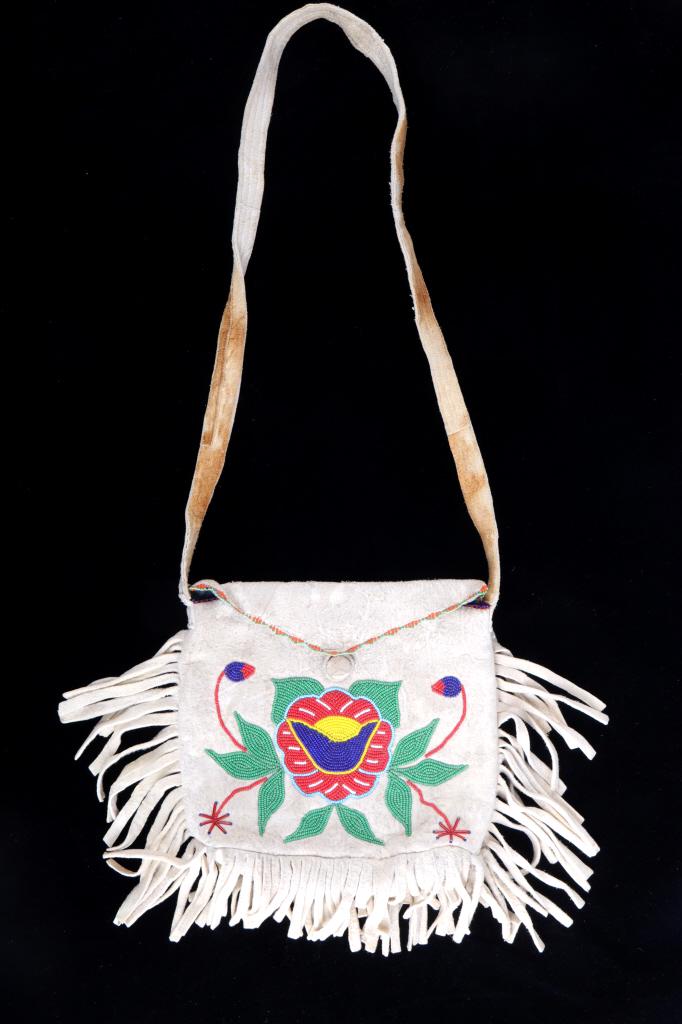 Montana Crow Beaded Bandolier Possible Bag c.1950-: The lot features a nice floral beaded Indian tanned hide shoulder bandolier possible bag from the Montana Crow Native American Indians dating to the 1950’s. The piece is comprised of thick Indian ta