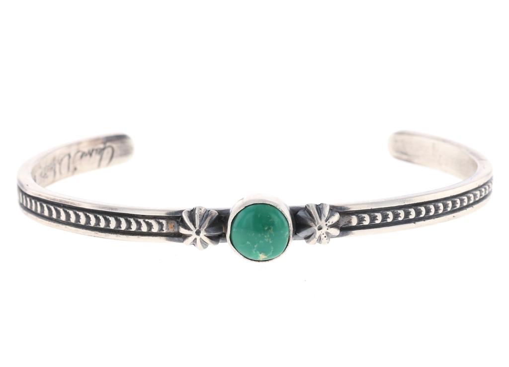 Navajo J. Deligarito Silver Sonoran Gold Bracelet: Featured in this lot is this sterling silver and Sonoran Gold turquoise bracelet from Navajo artist Jane Deligarito. The bracelet features a beautifully and professionally crafted, stamped, and emboss