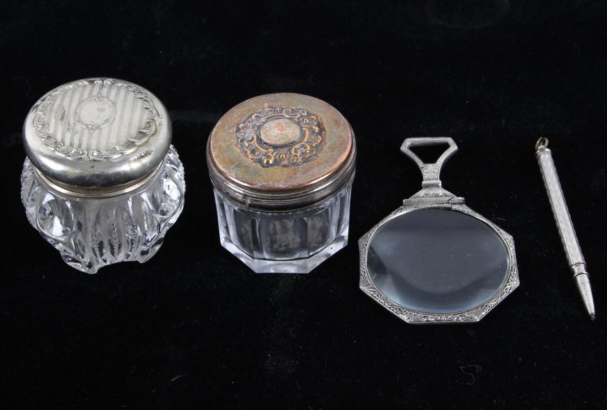 Sheffield Silver Vanity Jars & Articles Collection: Featured in this lot is a collection including Sheffield and German silver vanity jars, a silver pencil, and magnifying glass, circa 1890- 1910. There are four items in this collection. The first two