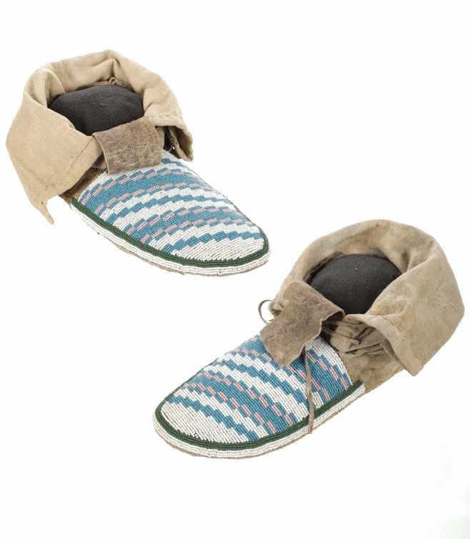 C. 1880 Blackfeet Beaded Hide Moccasins: The lot features a finely beaded set of hide moccasins dating to circa 1880 from the Blackfeet Native American Indians. The set shows an Indian tanned Buffalo hide with trade canvas muslin and blue wo
